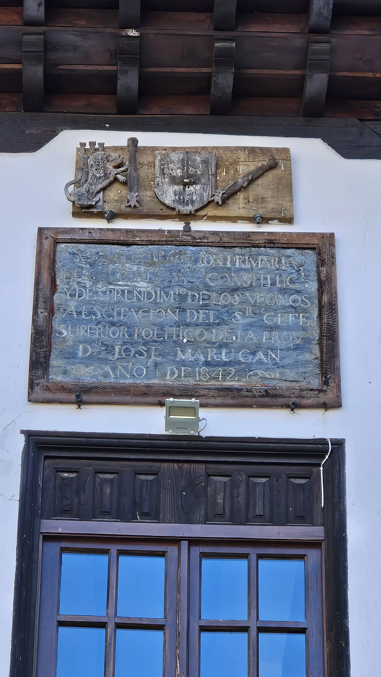 Foto de inscripción y escudo sobre balcón