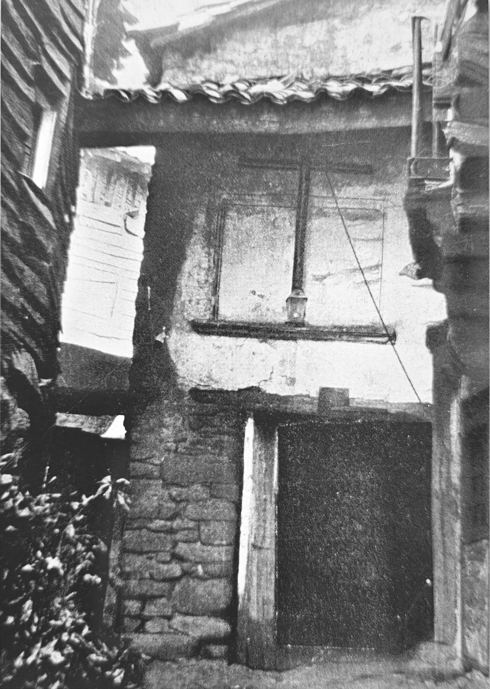 Foto en blanco y negro de fachada de hospital con cruz.