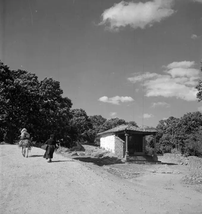 Foto de ermita con burro subiendo por el camino de su izquierda
